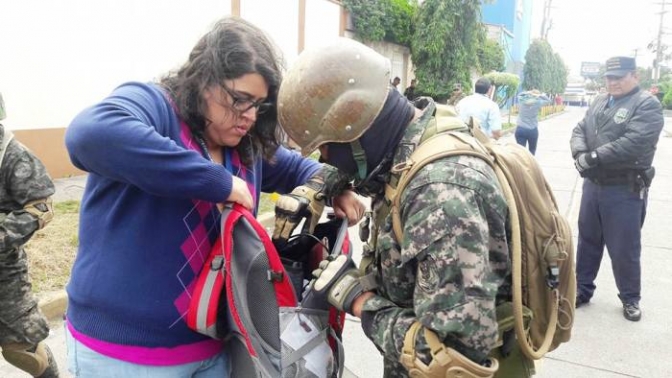 Elena Borjas, corresponsal de Radio Progreso en Tegucigalpa, mientras es minuciosamente registrada por un miembro del ejército