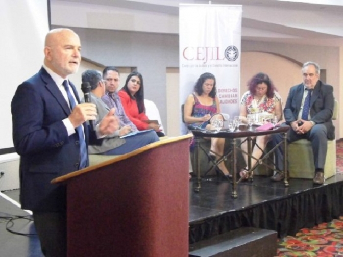 En la foto de pie está el Relator Michel Forst . Las personas sentada son: Indira Mendoza de Catrachas; Danilo Morales-Director del Mecanismo de Protección; Marcela Castañeda-Vice Ministra de Derechos Humanos; Marcia Aguiluz-CEJIL; Jessica Sánchez-Grupo de Sociedad Civil y Enrique Eguren de Protección Internacional.